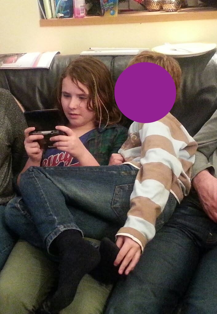 Young Laura on the couch with her childhood friend playing the DS Lite
